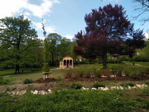 Der Park in Drackendorf. Blick auf das Teehaus. Davor eine kleine Sitzgruppe, umringt von vielen Pflanzen und Bäumen.