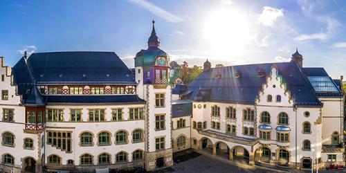 Blick auf das Volkshaus in Jena mit aufgehender Sonne