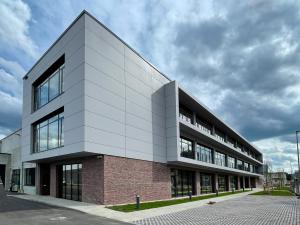 Gewerbehalle, deren Fassade im Erdgeschoss verklnkert ist und in den Obergeschossen mit Blech, Glaselementen und Balkonen gestaltet