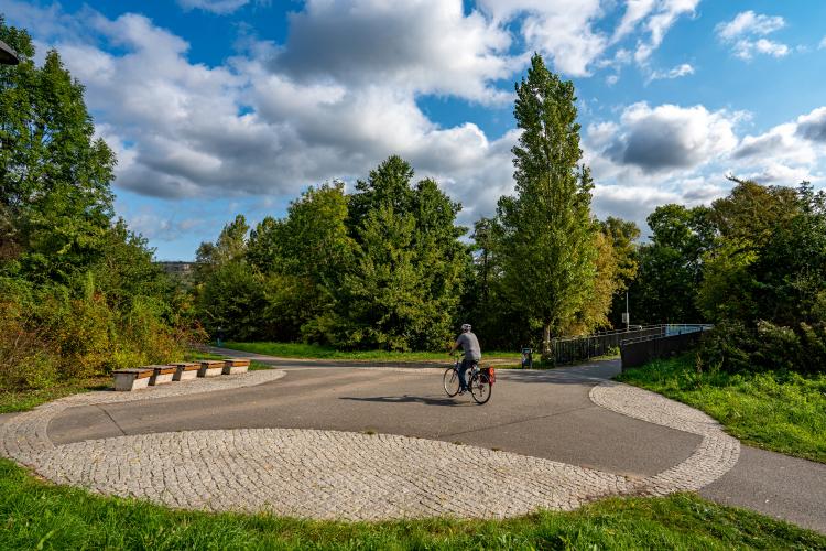 ein runder Kreuzungsbereich des Radweges an der Saale in Göschwitz, ein Radfahrer befährt diesen Bereich