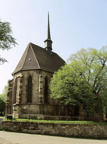 Kirche aus Natursteinen mit kleiner Mauer als Einfriedung